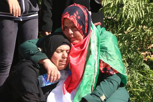 PALESTINE, Hebron: Violence continued in Hebron, Palestine on October 21, 2015 as Palestinians' held a funeral service for a fallen man. Women mourn over the grave of the man who was killed.Hebron was the latest scene of violence as an IDF soldier was stabbed by an attacker on Tuesday. The attacker was shot and killed after the stabbing. 