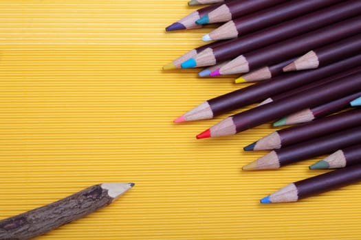 Colored pencils on yellow cardboard background