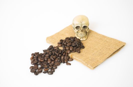 Coffee beans on a sack with skull on a white background.