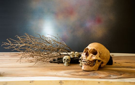Pile of human skulls on a log with branches into the background