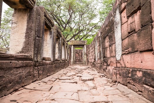 walkway in ancient castle with windows and door stone inscription among nature, pimai castle, historical park and ancient castle in nakhon ratchasima thailand, sandstone