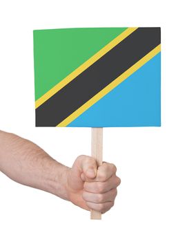 Hand holding small card, isolated on white - Flag of Tanzania