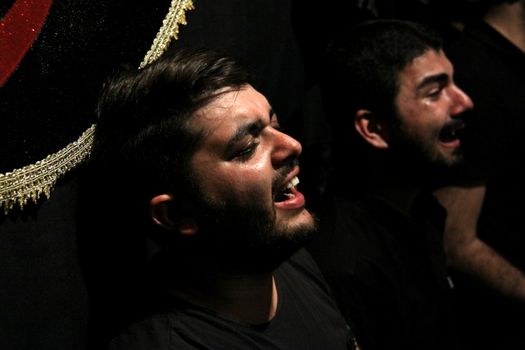 IRAN, Tehran : A man cries during a religion celebration while hundreds of Shia Muslims gather in Reyhane-Al-Hossein complex building for mourning session in tribute to imam Husayn ibn Ali on October 21, 2015, the 8th night of Muharram. one of the holy months in the Islamic calendar in Tehran, Iran. 