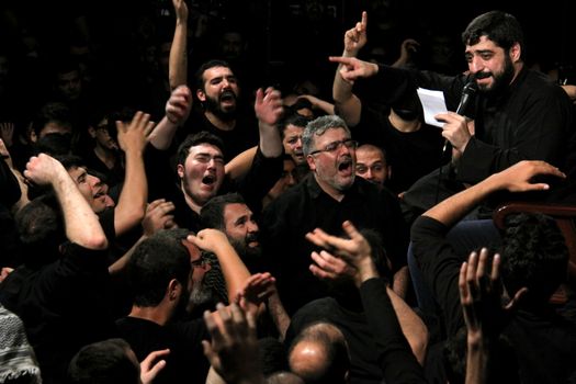 IRAN, Tehran : Hundreds of Shia Muslims cry and raise their hands in Reyhane-Al-Hossein complex building for mourning session in tribute to imam Husayn ibn Ali on October 21, 2015, the 8th night of Muharram. one of the holy months in the Islamic calendar in Tehran, Iran. 