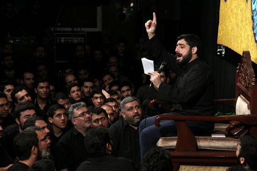 IRAN, Tehran : Hundreds of Shia Muslims listen to religious man in Reyhane-Al-Hossein complex building during mourning session in tribute to imam Husayn ibn Ali on October 21, 2015, the 8th night of Muharram. one of the holy months in the Islamic calendar in Tehran, Iran. 