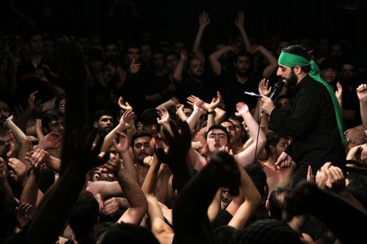 IRAN, Tehran : Hundreds of shirtless Shia Muslims raise their arms in Reyhane-Al-Hossein complex building for mourning session in tribute to imam Husayn ibn Ali on October 21, 2015, the 8th night of Muharram. one of the holy months in the Islamic calendar in Tehran, Iran. 