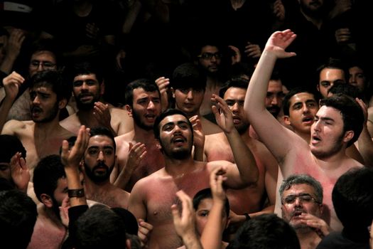 IRAN, Tehran : Hundreds of shirtless Shia Muslims shout in Reyhane-Al-Hossein complex building for mourning session in tribute to imam Husayn ibn Ali on October 21, 2015, the 8th night of Muharram. one of the holy months in the Islamic calendar in Tehran, Iran. 