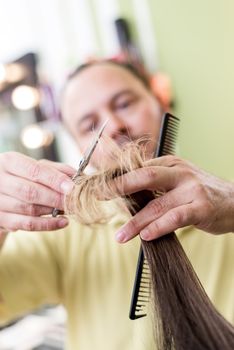 Man hairdresser cutting the hair of a woman. 