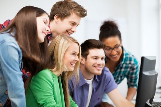 education concept - students looking at computer monitor at school