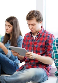 education and internet concept - student looking into tablet pc at school