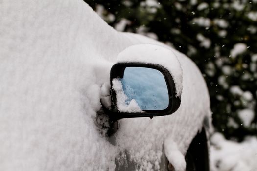 Photo of a snowy car's rearview mirror