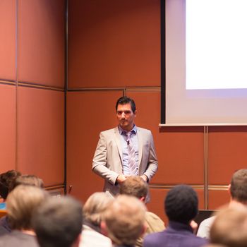 Speaker Giving a Talk at Business Meeting. Audience in the conference hall. Business and Entrepreneurship concept.