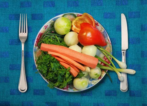 vegetables on white plate, knife and fork