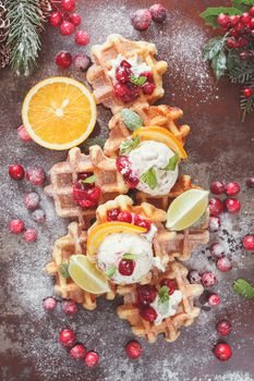 Homemade  waffles with  cranberries served with orange ice cream.  Festive decoration. Top view, vintage toned