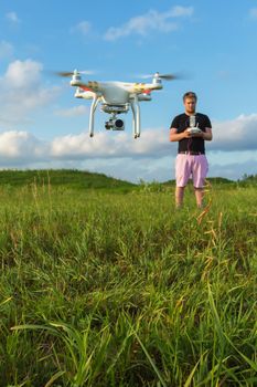 Single man in pink pants controlling drone outdoors