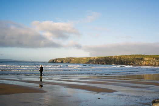 lone fisherman fishing on the beach in Ballybunion county Kerry Ireland