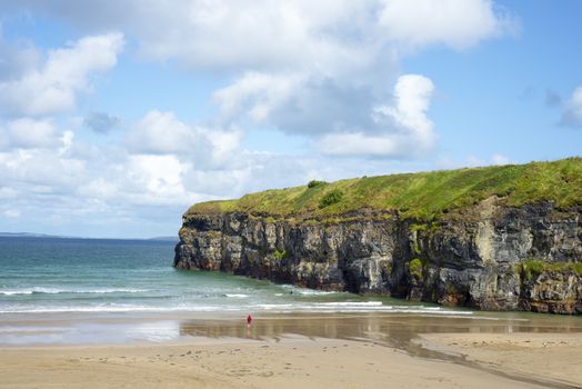 lone kayaker and tourist near the cliffs of ballybunion beach on the wild atlantic way ireland