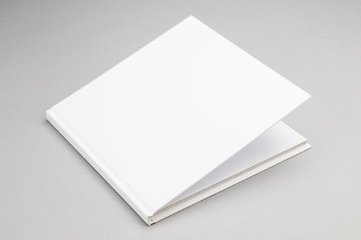 Blank book with ajar white cover 8,5 x 8,5 in