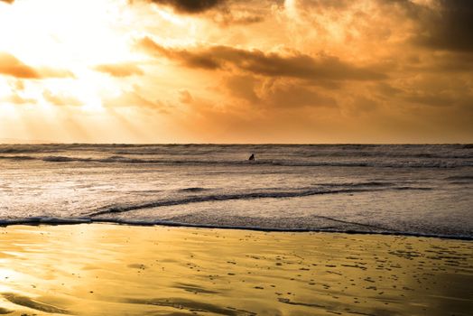 lone surfer surfing the winter waves at ballybunion beach on the wild atlantic way