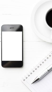 cellphone with notebook and coffee cup over white table