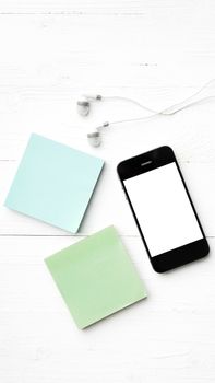 cellphone and sticky note over white table