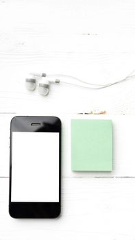 cellphone and sticky note over white table