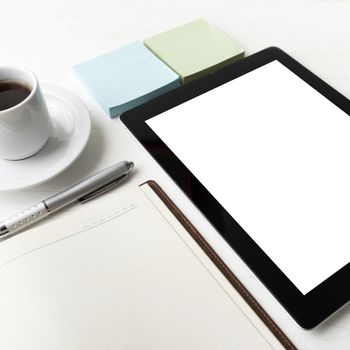 tablet with notebook and coffee cup over white table