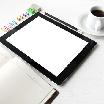 tablet with office supplies over white table