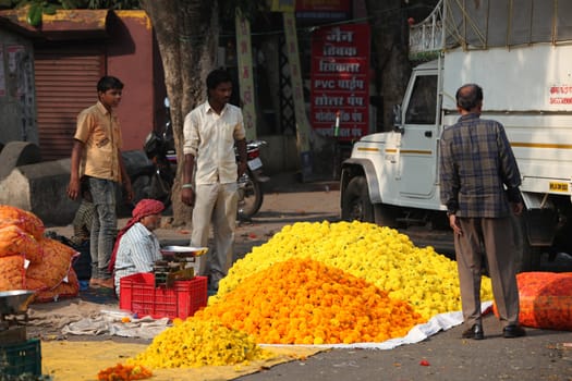Pune, India - October 21, 2015: A man selling marigold flowers to a customer on the streetside in India, on the eve of Dassera festival