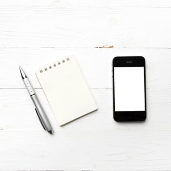 cellphone with notepad and pen over white table