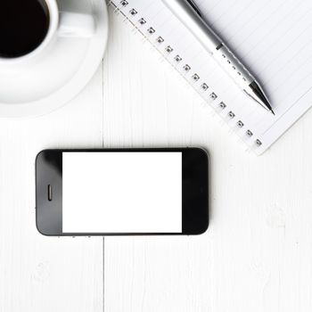 cellphone with notebook and coffee cup over white table