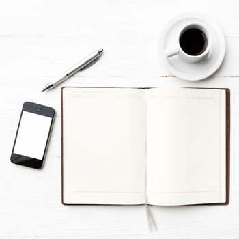 cellphone with notebook and coffee cup over white table