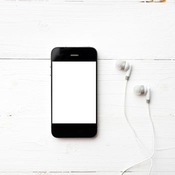 cellphone with earphone over white table