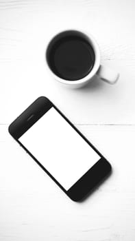 cellphone with coffee cup over white table black and white color style