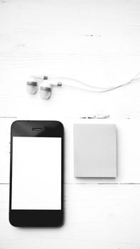 cellphone and sticky note over white table black and white color style