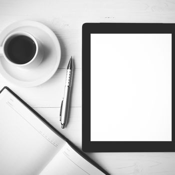 tablet with notebook and coffee cup over white table black and white color style