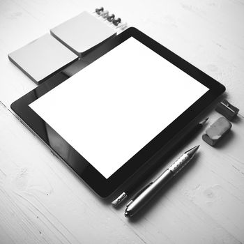 tablet with office supplies over white table black and white color style
