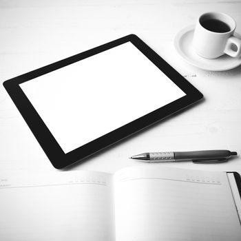tablet with office supplies over white table black and white color style