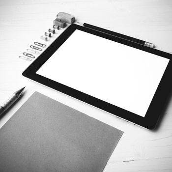 tablet with office supplies over white table black and white color style