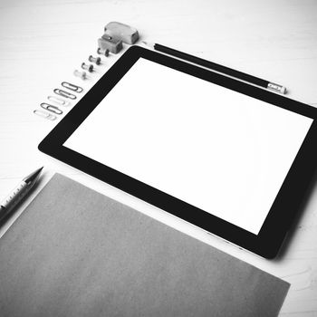 tablet with office supplies over white table black and white color style