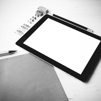 tablet with office supplies over white table black and white color style