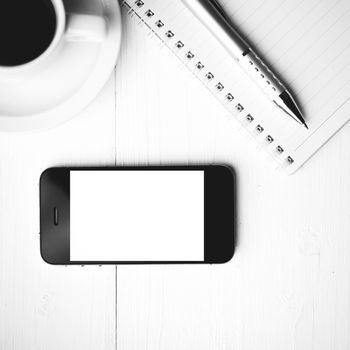 cellphone with notebook and coffee cup over white table black and white color style