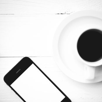 cellphone and coffee cup over white table black and white color style