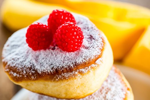 delicious german doughnuts powdered with sugar and raspberry on the top