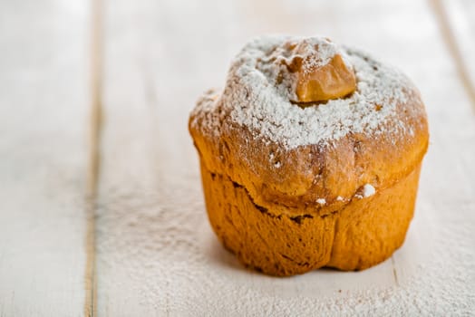 Small cakes with apple powdered with sugar on white wood table