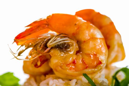 Dish with shrimps rice and green asparagus in a white plate, white background and white wood table