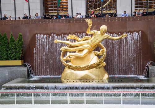 NEW YORK, USA, October 9, 2015: Unidentified people observing the Golden Prometheus statue at the Rockfeller Center Manhattan, New York.