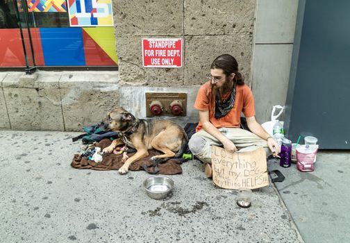 NEW YORK, USA, October 10, 2015: An unidentified homeless with his dog in Manhattan, New York City.