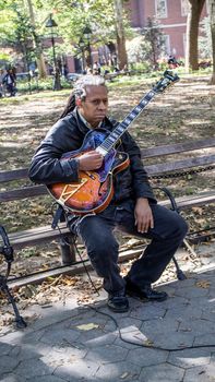 NEW YORK, USA, October 10, 2015: An unidentified lonely guitar player perform his songs in Washington Square Garden in Manhattan, New York.