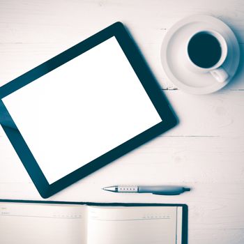 tablet with notebook and coffee cup over white table vintage style